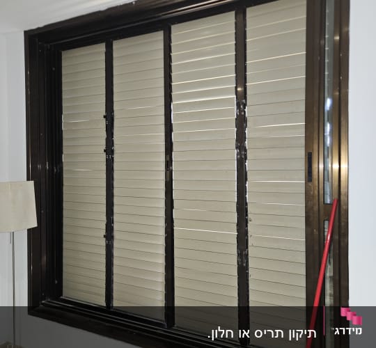 תריסים חומים בחלון גדול עם מטאטא אדום בצד